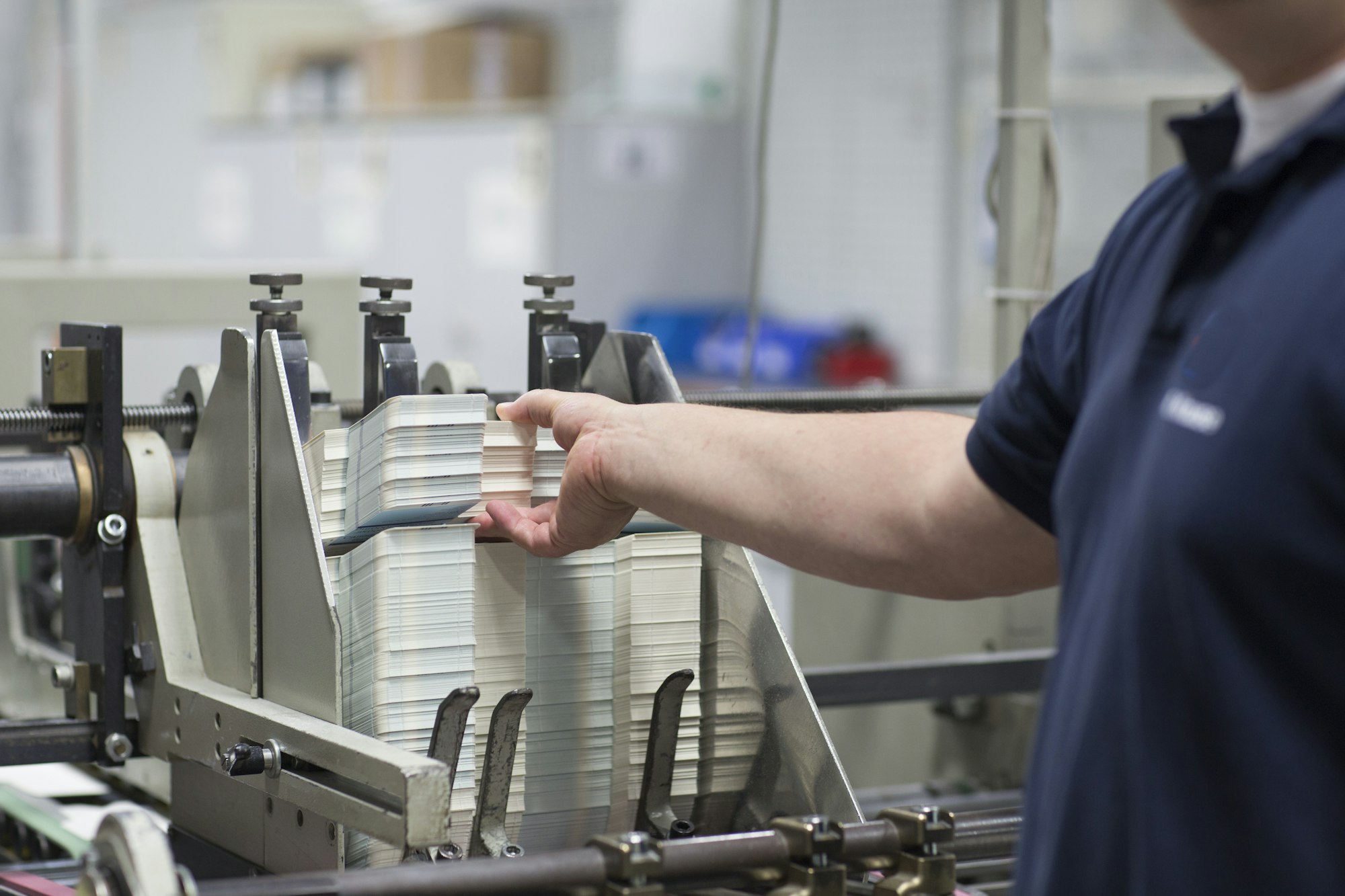 Worker using machine in paper packaging factory